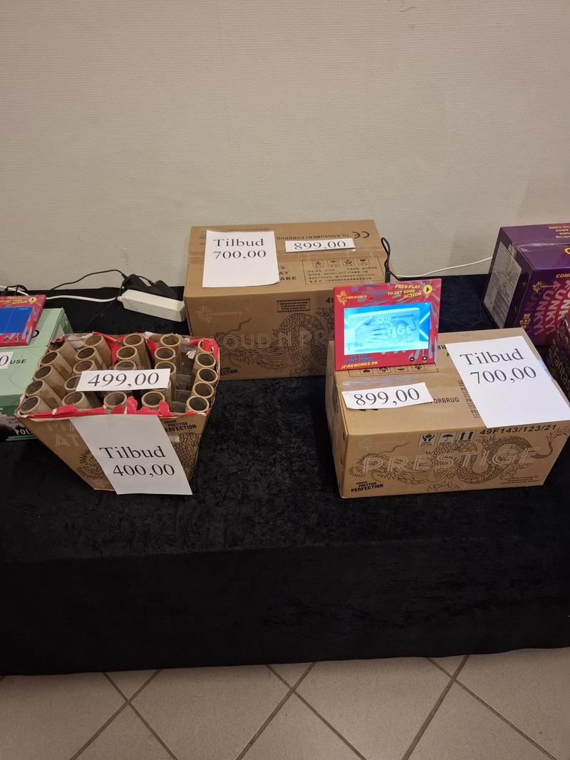 Salgsområde med raketter, fyrværkeripakker og udstillingsborde under fyrværkerisalg