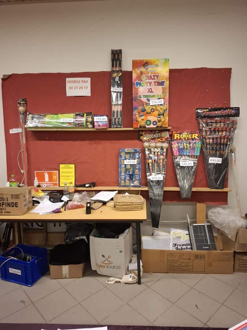 Raketter og fyrværkeripakker udstillet på reol i et fyrværkerisalg